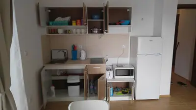 a small kitchen with a microwave and a refrigerator at Boulevard Sea Residence in Sunny Beach