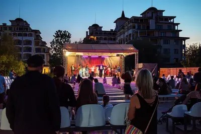 a group of people sitting in chairs watching a stage at Sunrise All Suites Resort- All Inclusive in Obzor