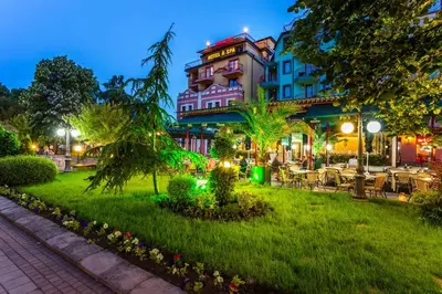 a hotel with a lawn in front of a building at Saint George Hotel & Medical Spa in Pomorie