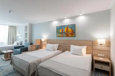 a hotel room with two beds and a couch at Hotel Neptun Beach in Sunny Beach