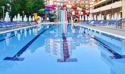 a swimming pool with chairs and a water slide at Hotel Laguna Park & Aqua Club - All Inclusive in Sunny Beach