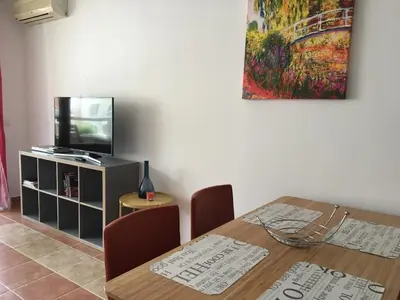 a dining room with a table and a television at Apartments Helios in Pomorie