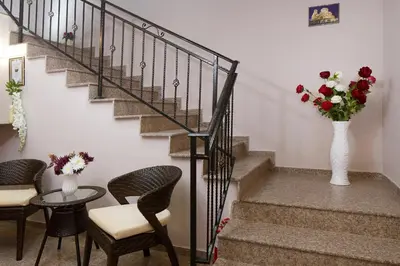 a staircase with a vase of flowers and a table and chairs at Feniks Apartments in Nesebar