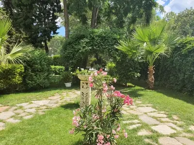 a garden with flowers and a planter in the grass at Hotel Riva Park - All Inclusive in Sunny Beach