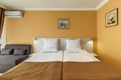 a large bed in a room with a couch at Hotel Riva Park - All Inclusive in Sunny Beach