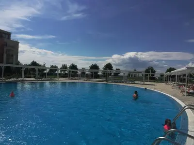 a large swimming pool with people in the water at Sea View Apartment PRESTIGE FORT BEACH , PREMIER FORT BEACH in Sveti Vlas