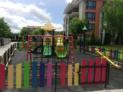 a playground in a park with a colorful fence at Sea View Apartment PRESTIGE FORT BEACH , PREMIER FORT BEACH in Sveti Vlas