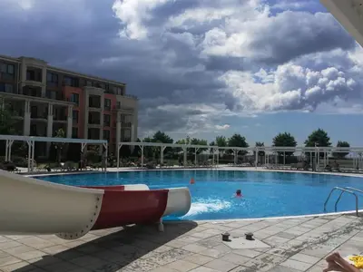 a large swimming pool with people in the water at Sea View Apartment PRESTIGE FORT BEACH , PREMIER FORT BEACH in Sveti Vlas