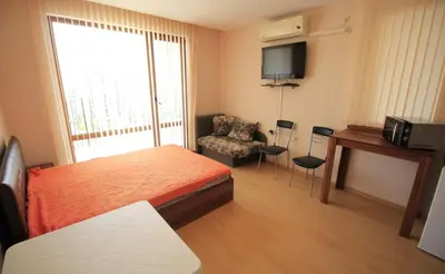a bedroom with a bed and a tv and a chair at Sea View Apartment PRESTIGE FORT BEACH , PREMIER FORT BEACH in Sveti Vlas