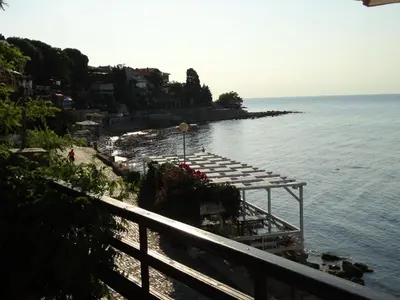 a beach with a row of benches next to the water at Apartments Anita in Nesebar