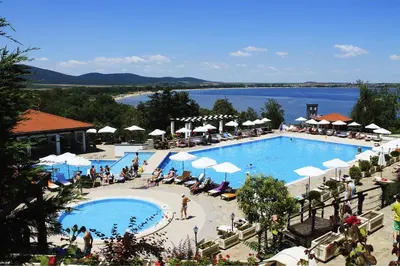 a large swimming pool with people sitting around it at Apartments DreamBG in Sozopol