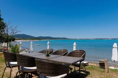 a table and chairs with a view of the water at Apartments DreamBG in Sozopol