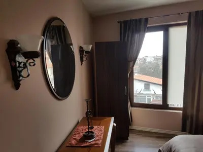 a bedroom with a mirror and a table and a window at Apartments Stefanov in Byala in Byala