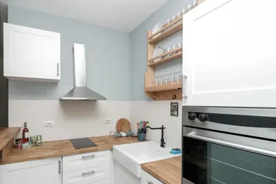 a kitchen with white cabinets and a sink and a stove at Sea Crib Apartment in Varna City