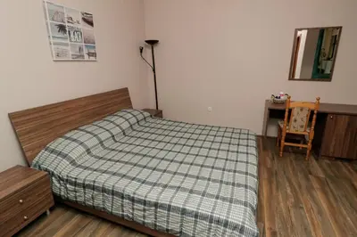 a bedroom with a bed and a table and a chair at Sea Crib Apartment in Varna City