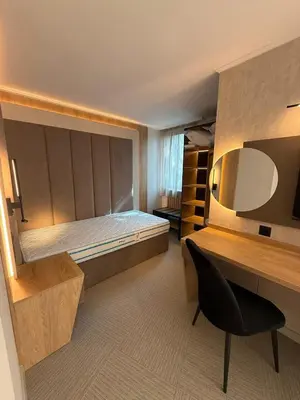 a bedroom with a bed and a desk and a chair at Hotel Luxor in Burgas City