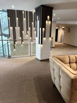 a lobby with a couch in the middle of a building at Hotel Luxor in Burgas City