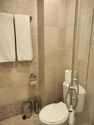 a bathroom with a toilet and a shower with towels at Avalon Apartament in Sunny Beach