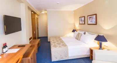 a hotel room with a bed and a desk at Fjord B&B in Sozopol