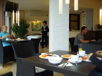 a group of people sitting at a table in a restaurant at Fjord B&B in Sozopol