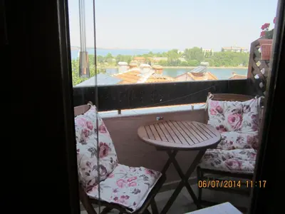 a balcony with two chairs and a table and a window at Guesthouse Olimp in Sozopol