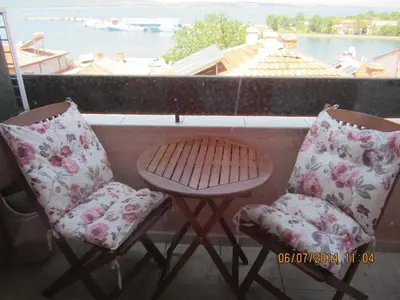 a balcony with two chairs and a table and a window at Guesthouse Olimp in Sozopol