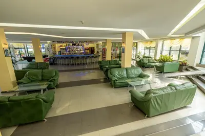a lobby with green couches and chairs in a store at Hotel Slavyanski in Sunny Beach