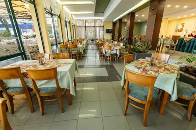 a dining room with tables and chairs and a unintention at Hotel Slavyanski in Sunny Beach