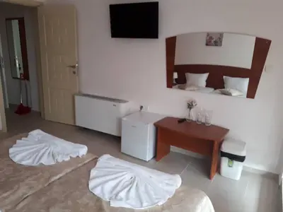 a room with a bed and two white sheets on the floor at CAPUCCINO GUEST APARTMENTS - FREE PARKING and Wi-Fi in Sunny Beach