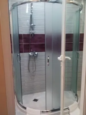a shower with a glass door in a bathroom at CAPUCCINO GUEST APARTMENTS - FREE PARKING and Wi-Fi in Sunny Beach