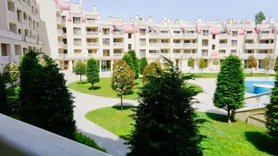 an apartment complex with a courtyard with trees and a building at Апартаменти Варна Саут на плажа - Varna South Apartments on the beach in Varna City