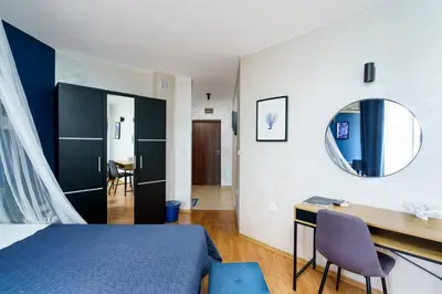 a bedroom with a bed and a desk and a mirror at Sunrise Hotel in Primorsko