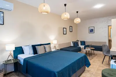 a bedroom with a blue bed and a couch at Sunrise Hotel in Primorsko