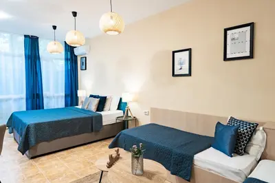 a hotel room with two beds and a couch at Sunrise Hotel in Primorsko