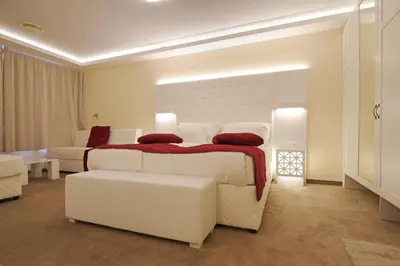 a large white bedroom with a bed and a couch at Hotel Perla Beach Luxury - All Inclusive & Free Beach Access in Primorsko