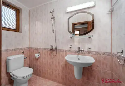 a bathroom with a toilet and a sink and a mirror at Hotel Chuchulev in Sozopol