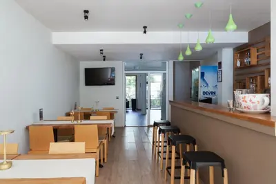 a restaurant with wooden tables and chairs and a bar at Hotel Milan in Primorsko