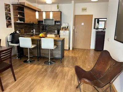 a kitchen with a counter and chairs in a room at Edmond Apartment-Highspeed-Internet-Free! in Aheloy