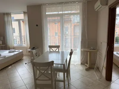 a living room with a table and chairs and a bed at Dawn Park Complex in Sunny Beach