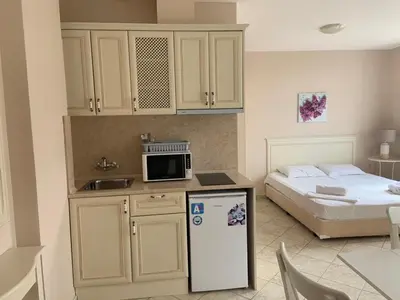 a room with a bed and a kitchen with a refrigerator at Dawn Park Complex in Sunny Beach