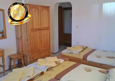 a bedroom with two beds and a clock on the wall at Pension Dicev in Obzor