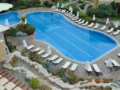 a large swimming pool with lounge chairs and umbrellas at Болгария, г.Свети Влас, к.
