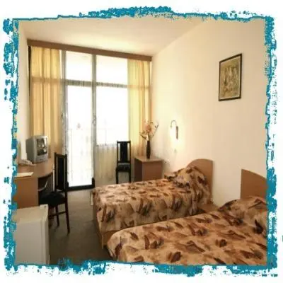 a hotel room with two beds and a desk at Hotel Trakia Garden in Sunny Beach