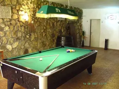 a pool table in front of a stone wall at Hotel Trakia Garden in Sunny Beach