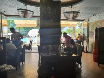a group of people sitting at tables in a restaurant at Yassen Holiday Village in Sunny Beach