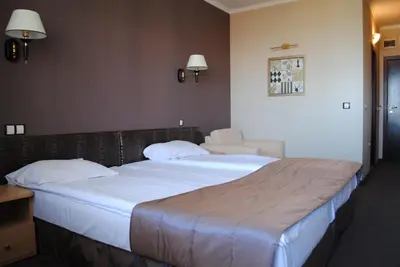 a hotel room with two beds and a chair at Guest House Palazzo in Byala