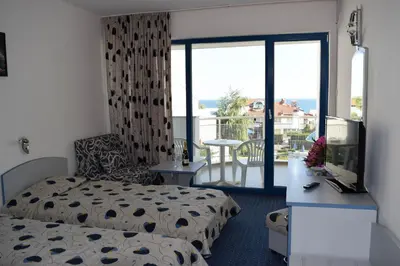 a bedroom with a bed and a desk with a television at Sineva Park Hotel - All Inclusive in Sveti Vlas