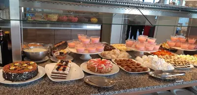 a buffet filled with different types of cakes and desserts at Sineva Beach Hotel - All Inclusive in Sveti Vlas