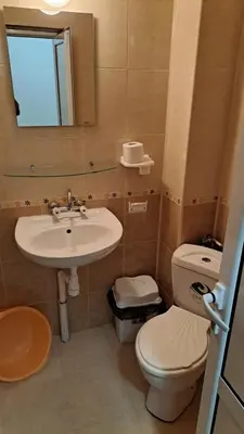 a bathroom with a sink and a toilet and a mirror at Primorsko Apartments in Primorsko