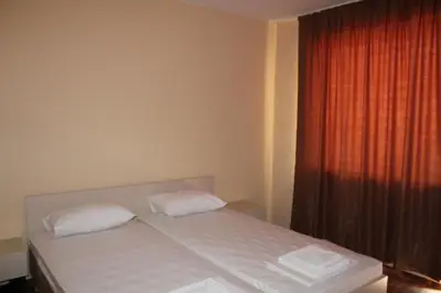 a bedroom with a bed with two pillows and a window at Hotel Sapphire in Primorsko